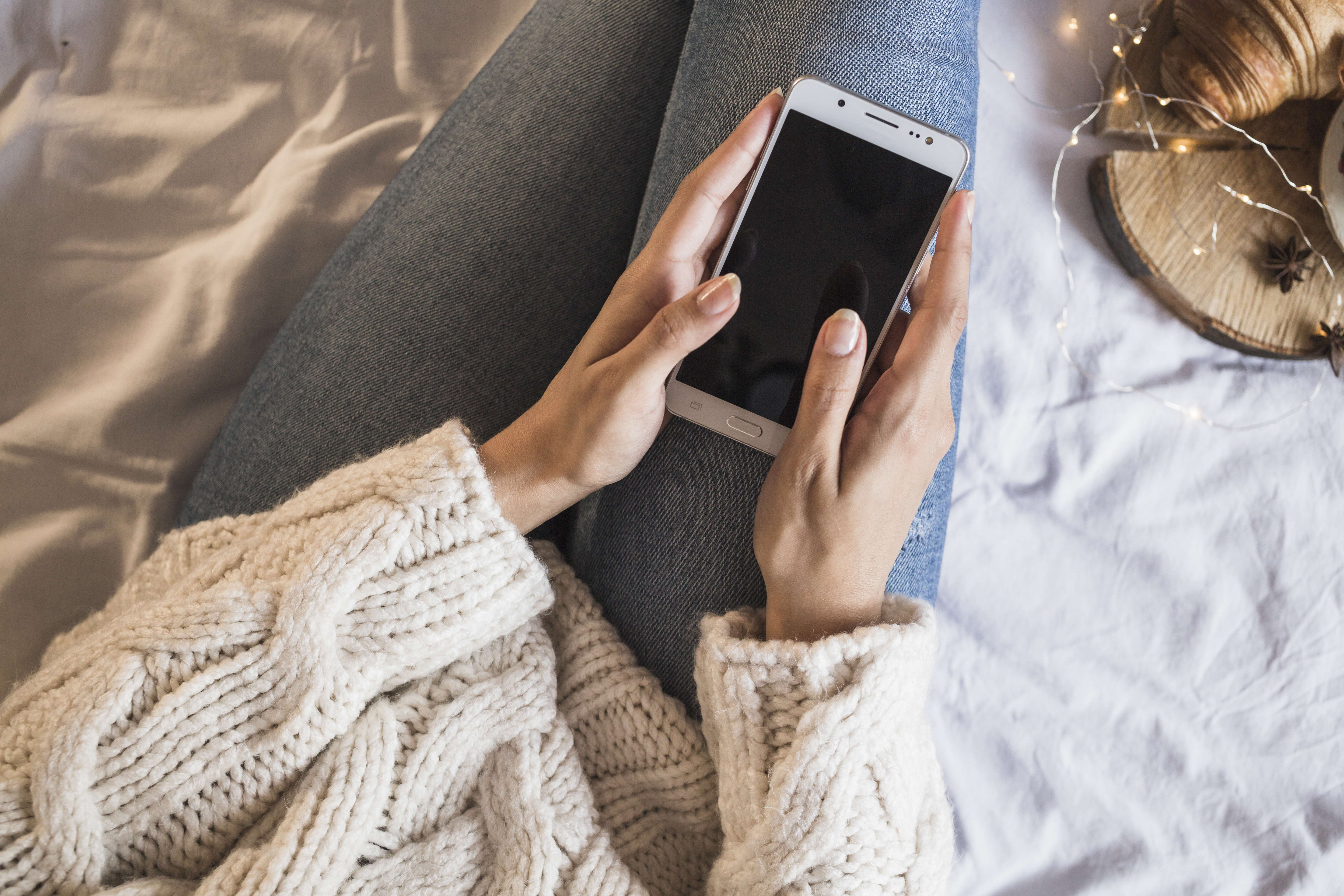 woman-sitting-bed-using-smartphone